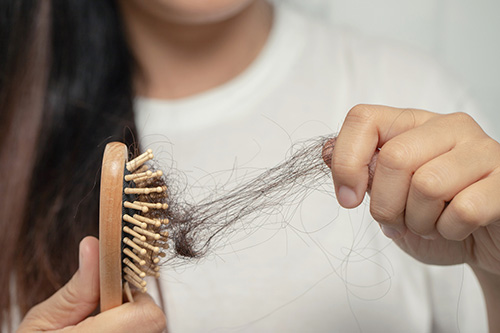 A woman struggling with hair loss in menopause