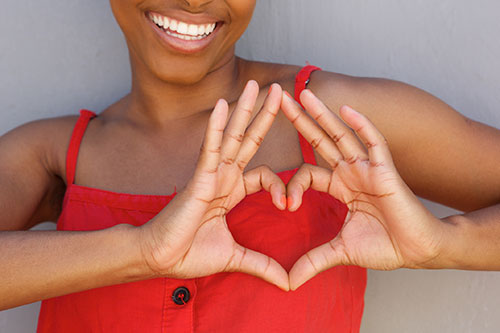 A Woman Making A Heart Shape To Draw Attention To Natural Heart Health For Women