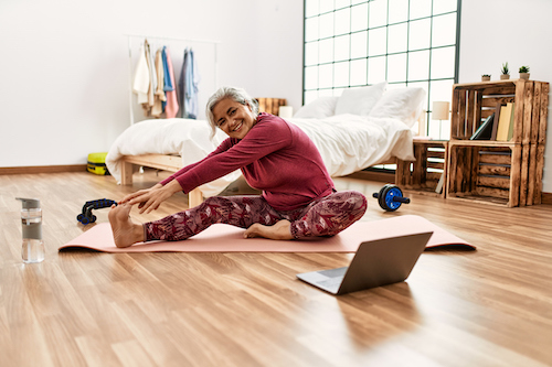 Middle age woman doing yoga in her home