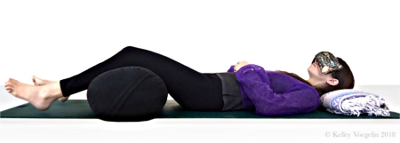 Woman doing Corpse Pose in yoga to reduce stress