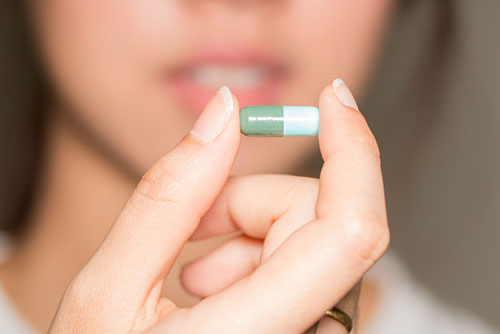 A woman is taking an antibiotic for recurrent UTIs