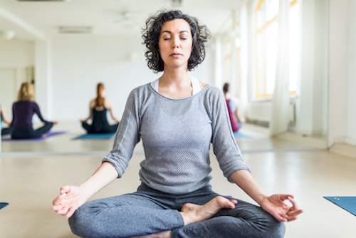 Woman meditating as a way to reduce bone loss during menopause.